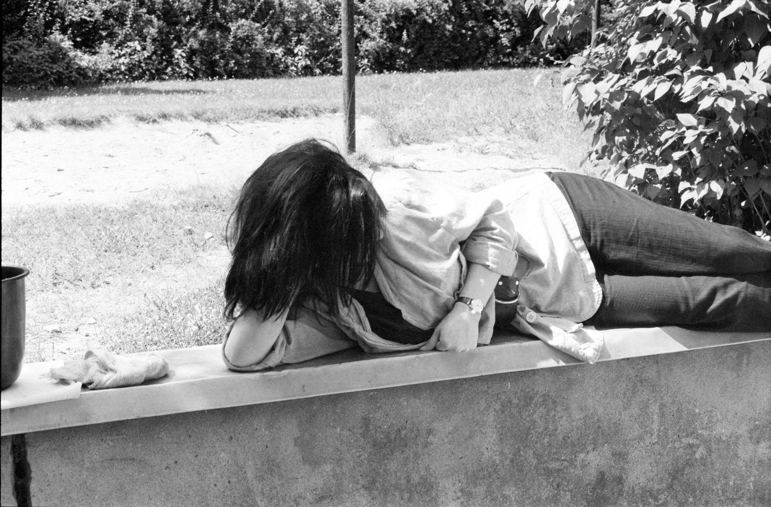 Preparation Seminar in Kladow - A young woman is lying on a low wall.