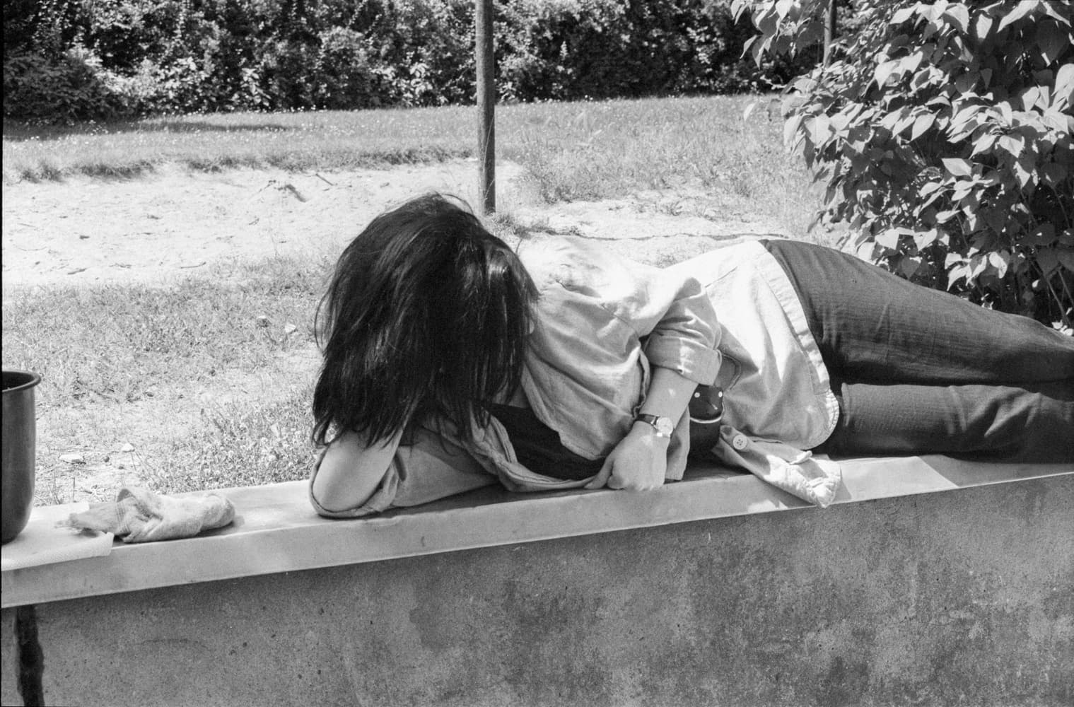 Preparation Seminar in Kladow - A young woman is lying on a low wall.