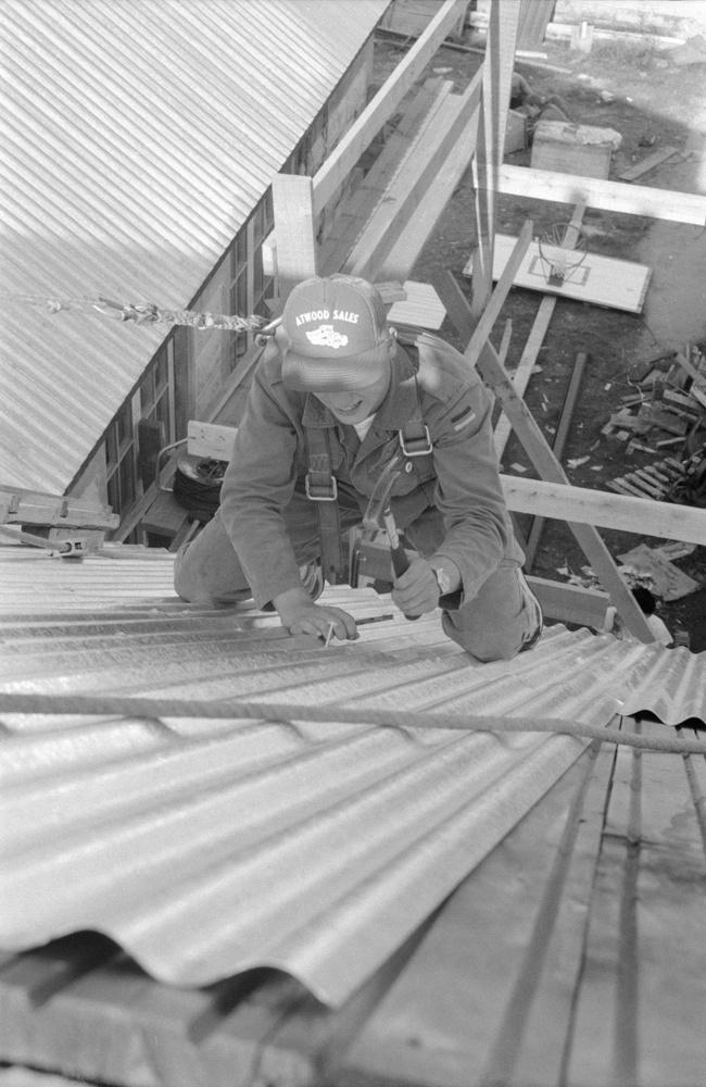 Roofing work 1987- A participant drives a nail with a carpenter's hammer